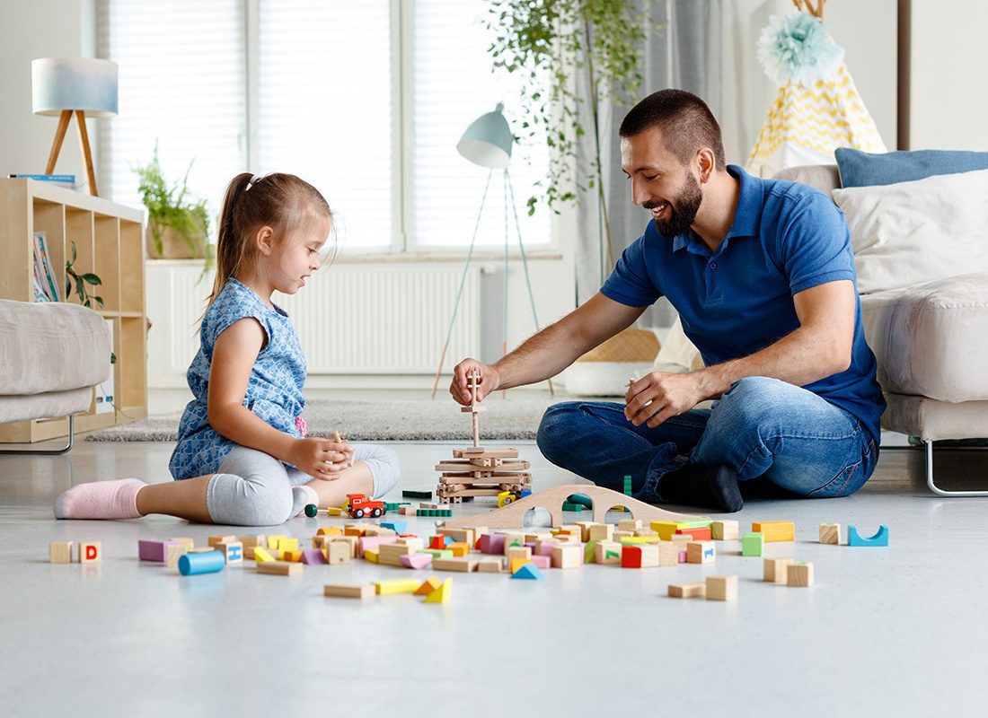 Personal Insurance - Father Plays With Blocks With His Daughter at Home